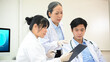 © bongkarn - A team of professional Asian scientist discussing on their Pharmaceutical experiment research