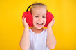 happy Cute little girl wearing stylish red earmuffs on yellow background