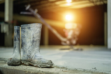 Black rubber construction worker shoes laid on concrete.