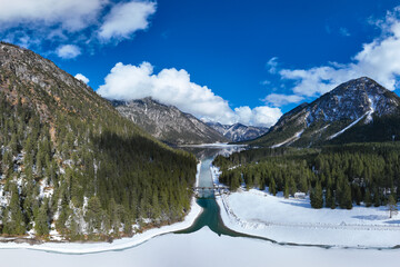 Wall Mural - view of the see canal with the old wooden bridge in the direction of the natural jewel of the plansee in winter