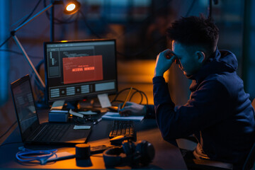 cybercrime, hacking and technology concept - male hacker in dark room writing to notebook and using 