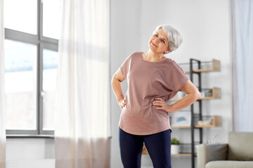 Poster - sport, fitness and healthy lifestyle concept - smiling senior woman exercising at home