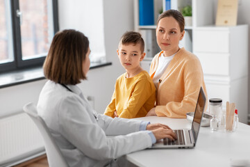 Wall Mural - medicine, healthcare and pediatry concept - mother, little son and doctor with laptop computer at clinic