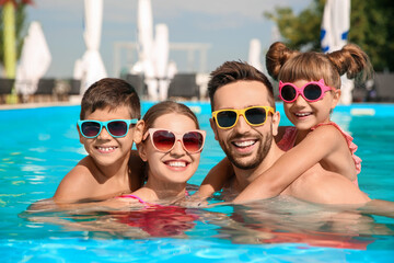 Canvas Print - Happy family in swimming pool on sunny day