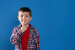 © New Africa - Thoughtful little boy on blue background, space for text