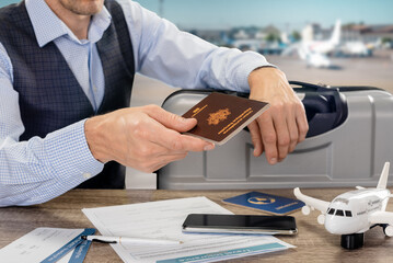 Wall Mural - Male tourist giving his identification document for travel to customs officer in airport, inscription European Union French Republic passport