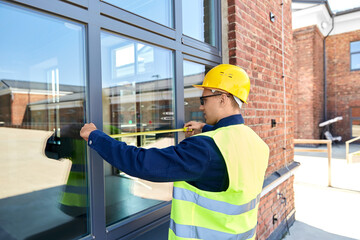 Sticker - construction business and building concept - male builder with ruler measuring window