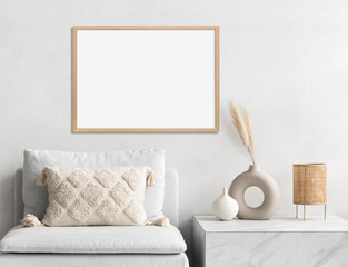 Blank picture frame mockup on white wall. White living room design. View of modern Boho style interior with chair. Home staging and minimalism concept