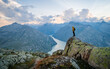 © Pavel Kašák - Adventurous man hiker standing on top of a rocky mountain overlooking the dramatic landscape at sunset. Background image from sediment gray Grimselsee lake, Switzerland. Adventure Concept Artwork