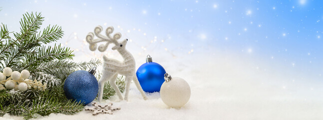 banner with blue and white christmas decorations on the snow.