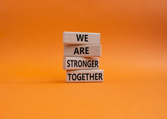 Wall Mural - We are stronger together symbol. Wooden blocks with words We are stronger together. Beautiful orange background. We are stronger together concept. Copy space.