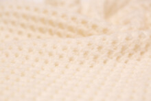 Knitted Surface Of Woolen Things As A Background. Close-up Of Soft White Texture Of Knitted Patterns. Warm Winter Clothes. Background Textile Surface With Copy Space For Text.