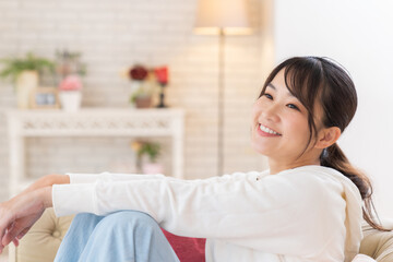 Wall Mural - 部屋でリラックスする若い女性