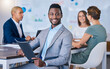 © Sanele Gobinduku/peopleimages.com - Portrait of a confident business man leading a meeting in a modern office, smiling and empowered. Happy black male discussing innovative strategies, marketing, planning and creative startup strategy