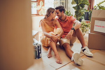 Canvas Print - Romance, fun and an intimate moment between a couple moving into a new home. Young lovers being affectionate, flirting and enjoying a conversation. Husband and wife taking a break from unpacking