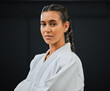. Karate, judo or taekwondo woman in white kimono for martial arts, jiu jitsu and kung fu against a black studio background. Portrait of a determined, serious and focused fighter ready for combat.