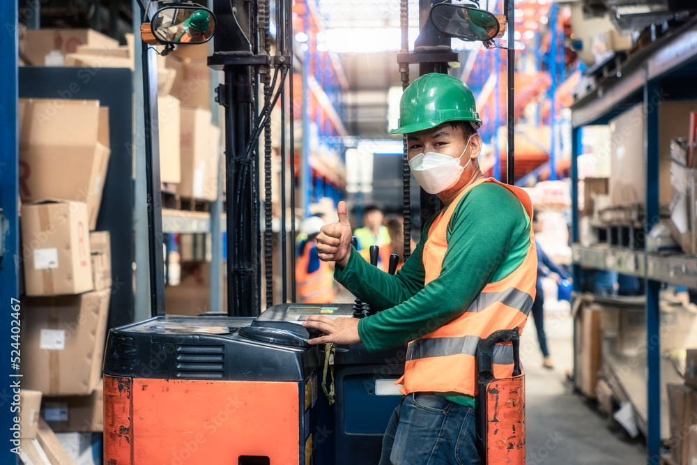 Worker Operator Portrait of forklift operator with thumb in distribution warehouse. May ...