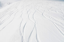 Top View Of The Snow-covered Slope Of The Mountain, Traces From Skiers And Snowboarders, No People