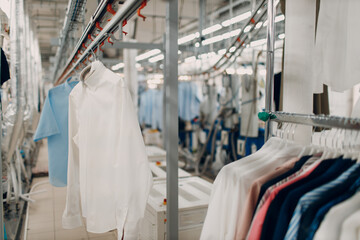 Dry cleaning clothes. Clean cloth chemical process. Laundry industrial dry-cleaning hanging clothes on rack