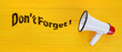 © Pixel-Shot - Megaphone and text DON'T FORGET on yellow wooden background