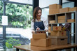 © Natee Meepian - Starting small businesses SME owners female entrepreneurs Use a digital tablet to receive and review orders online to prepare to pack boxes, sell to customers, SME online business.