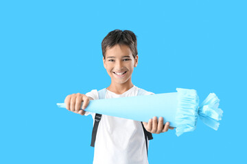 Wall Mural - Little boy with school cone on blue background