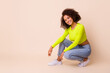 Full length photo of lovely young lady curly hair new clothes shop banner dressed stylish yellow look isolated on beige color background