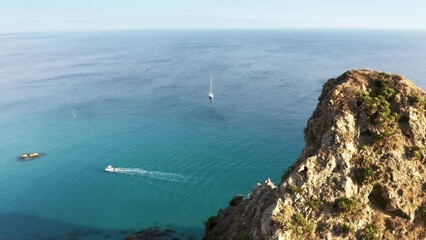 Wall Mural - Passing through the top of cliff on the calm summer sea in Italy