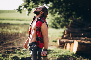 Male lumberjack  with an axe in forest