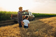 © cherryandbees - father and son examine wheat on wheat field