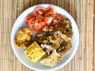 Wall Mural - Ayam geprek (smashed fried chicken), fried tofu with slices tomatoes.