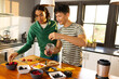 © Wavebreak Media - Happy biracial lgbt male couple preparing healthy drink together in kitchen