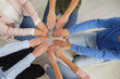 © Studio Romantic - Close up top view of diverse employees sit in circle join hands palms together showing unity. Multiracial people engaged in teambuilding training. Office diversity. Teamwork concept.