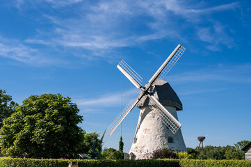 Dutch-type windmill in Araisi, Latvia. Sunny summer day. Old Europe style. Blue sky. Green grass.