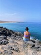 Young woman observing a beautiful paradisiacal landscape on the island of Fuerteventura