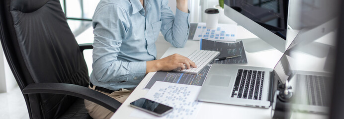 Professional development programmers are sit on a desk with work equipment such as: computer-laptop-tablet. for working in programming or writing code on  website,  HTML, javascript, Software.