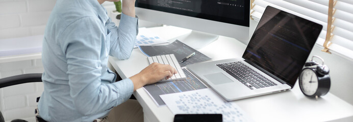 Professional development programmers are sit on a desk with work equipment such as: computer-laptop-tablet. for working in programming or writing code on  website,  HTML, javascript, Software.