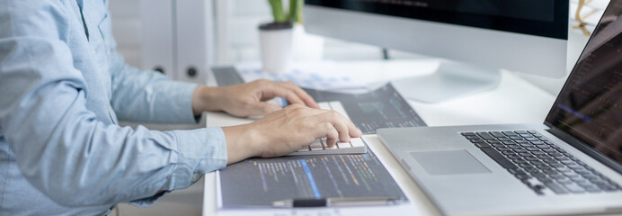 Professional development programmers are sit on a desk with work equipment such as: computer-laptop-tablet. for working in programming or writing code on  website,  HTML, javascript, Software.