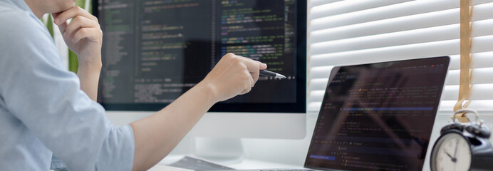 Professional development programmers are laying out a structure or draft on paper in preparation for coding on a computer, Write information or code for the website,  HTML, javascript, Software.