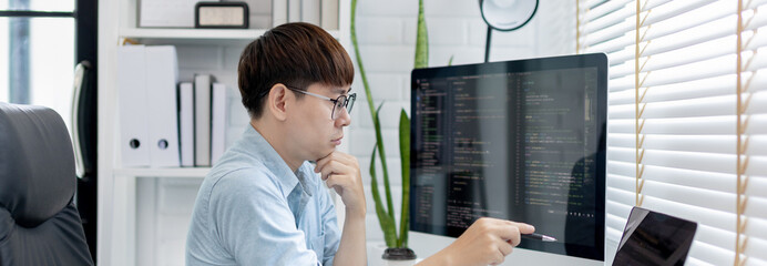 Professional development programmers are laying out a structure or draft on paper in preparation for coding on a computer, Write information or code for the website,  HTML, javascript, Software.