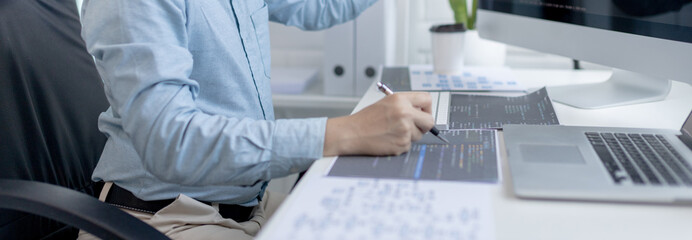 Professional development programmers are laying out a structure or draft on paper in preparation for coding on a computer, Write information or code for the website,  HTML, javascript, Software.