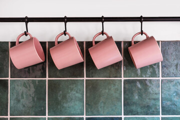 Wall Mural - metal hanging rack with mugs at kitchen