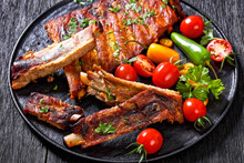 BBQ Ribs With Tomatoes And Chili On  Black Plate