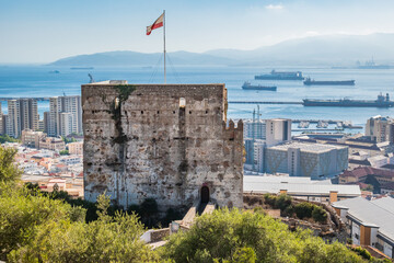 The Moorish Castle's Tower of Homage with a flag in Gibraltar and Africa in the horizon mountains