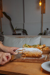 person slicing bread in kitchen