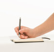 © serhii - female hand writes in a notebook on a white background isolated