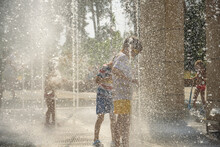 Boy Having Fun In Water Fountains. Child Playing With A City Fountain On Hot Summer Day. Happy Kids Having Fun In Fountain. Summer Weather. Active Leisure, Lifestyle And Vacation