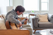 © Kristen - Young man sitting on the couch playing guitar