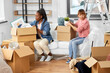 Leinwandbild Motiv moving, people and real estate concept - women unpacking boxes at new home