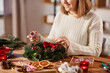 © Syda Productions - winter holidays, diy and hobby concept - close up of happy smiling woman with decorative rope making christmas wreath at home